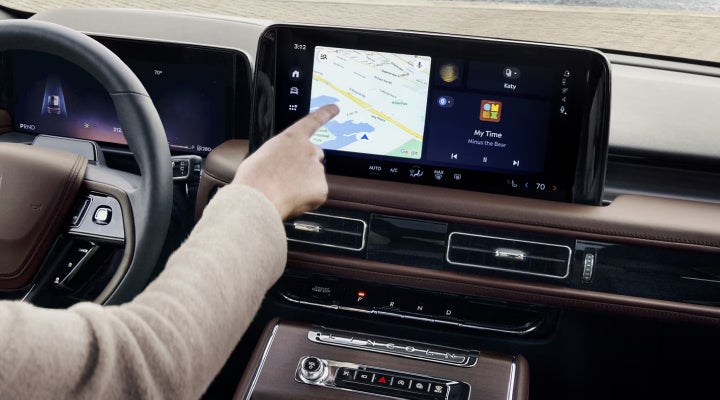 A person is tapping the center display touchscreen of a 2026 Lincoln Aviator® SUV. | Capital Lincoln of Wilmington in Wilmington NC