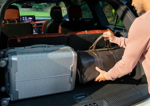 A man loads luggage into the rear of a 2026 Lincoln Aviator® SUV through the opened rear liftgate. | Capital Lincoln of Wilmington in Wilmington NC