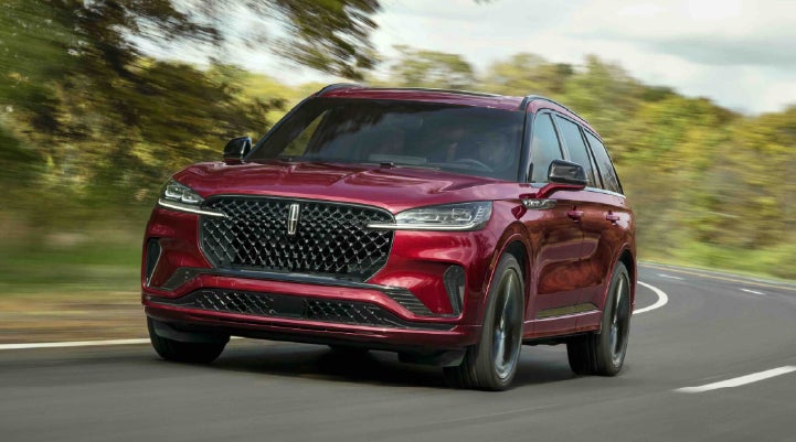 A 2027 Lincoln Aviator® SUV is being driven on a country road | Capital Lincoln of Wilmington in Wilmington NC