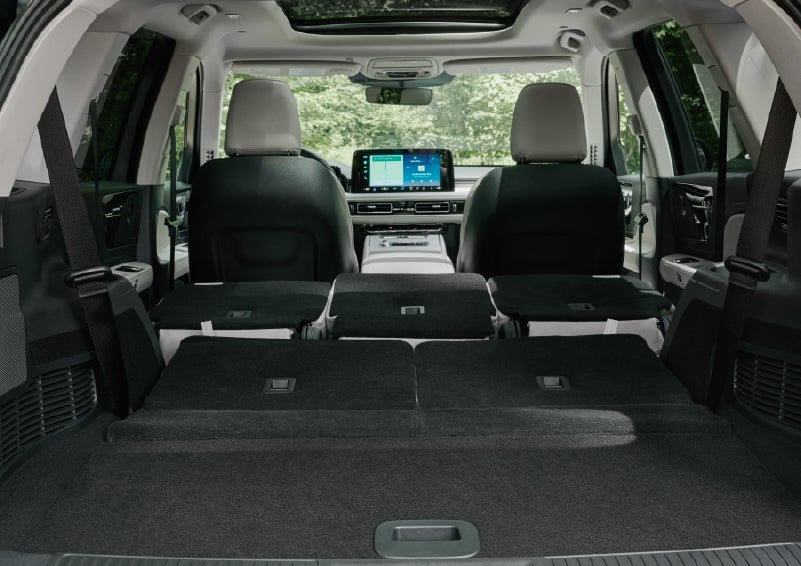 A rear to front view of the interior of a 2027 Lincoln Aviator® Black Label™ SUV shows the third and second rows folded flat | Capital Lincoln of Wilmington in Wilmington NC