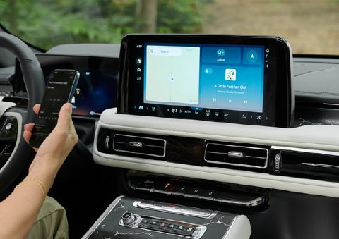 A person pairs thier phone with the center touchscreen of a 2027 Lincoln Aviator® Black Label™ SUV | Capital Lincoln of Wilmington in Wilmington NC