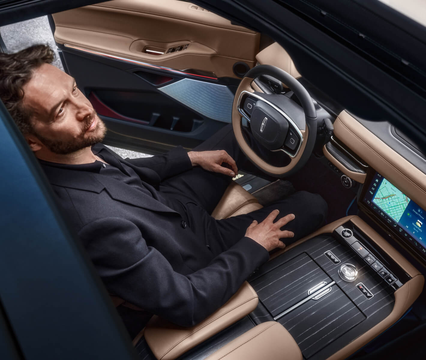 Man sitting in a Lincoln looking up