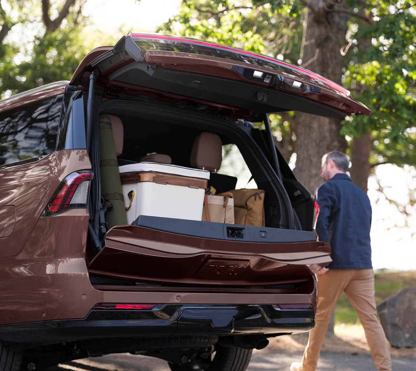 Exterior rear image of 27 Lincoln Navigator with open tailgate and trunk full of picnic supplies.
