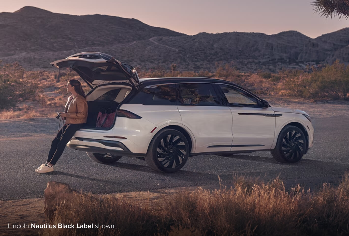Woman sitting in trunk of Lincoln Nautilus Black Label
