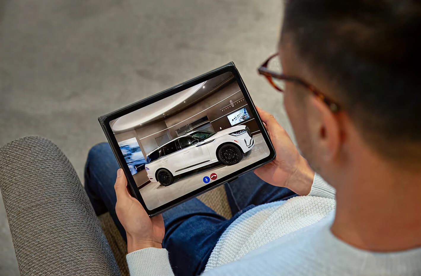 Customer looking at lincoln showroom vehicle on ipad
