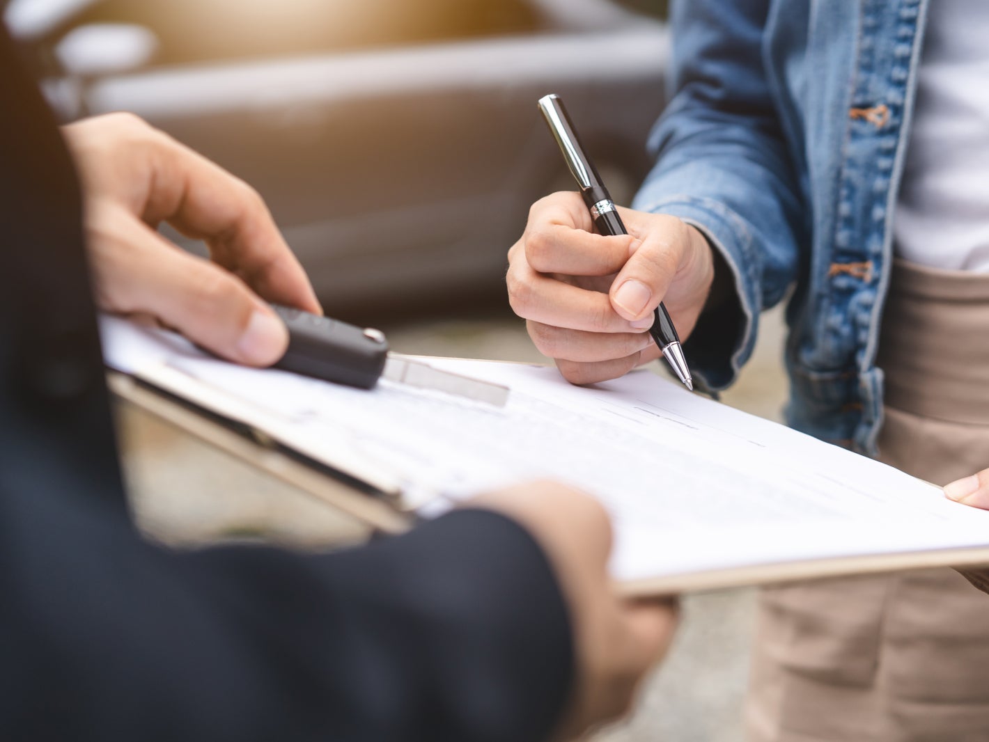 Close-up of a customer signing papers