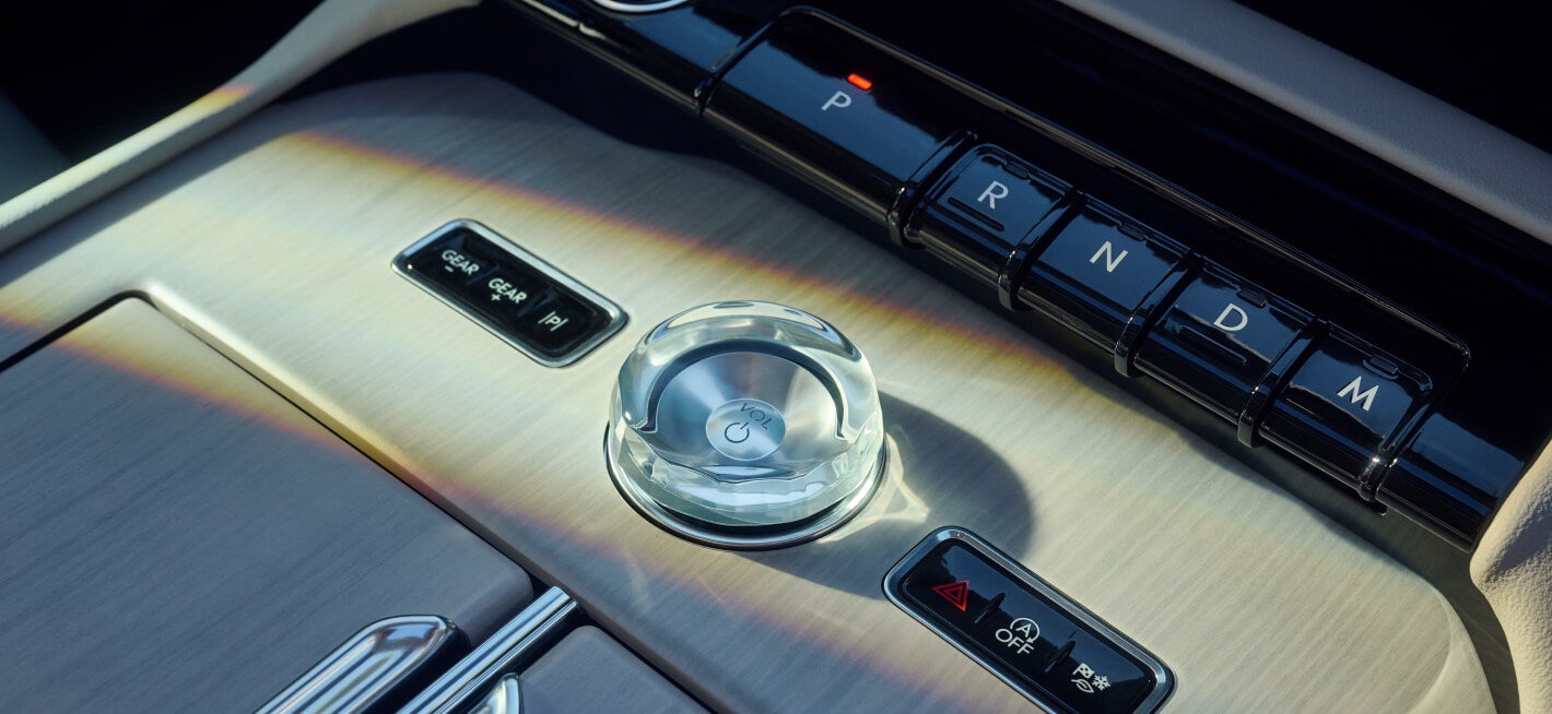 Close-up of a 2026 Lincoln Navigator Reserve console featuring a crystal volume knob.