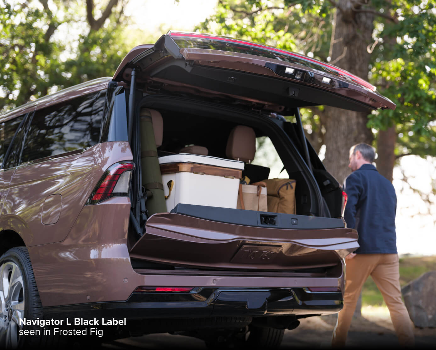 2027 Lincoln Navigator L Black Label in Frosted Fig, rear view with split tailgate open and cargo loaded outdoors.